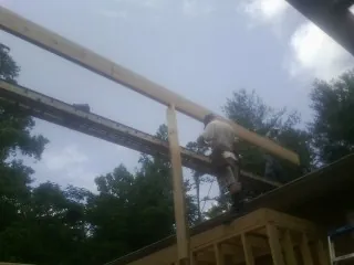 Carpenter setting a ridge beam over a new addition frame — Ice Dam Removal by Roofing Brothers in Pleasant View