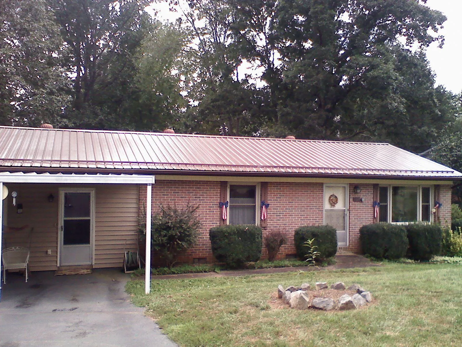 Bronze metal roof and carport on a brick ranch home — Roof Repair work by our crew in Pleasant View