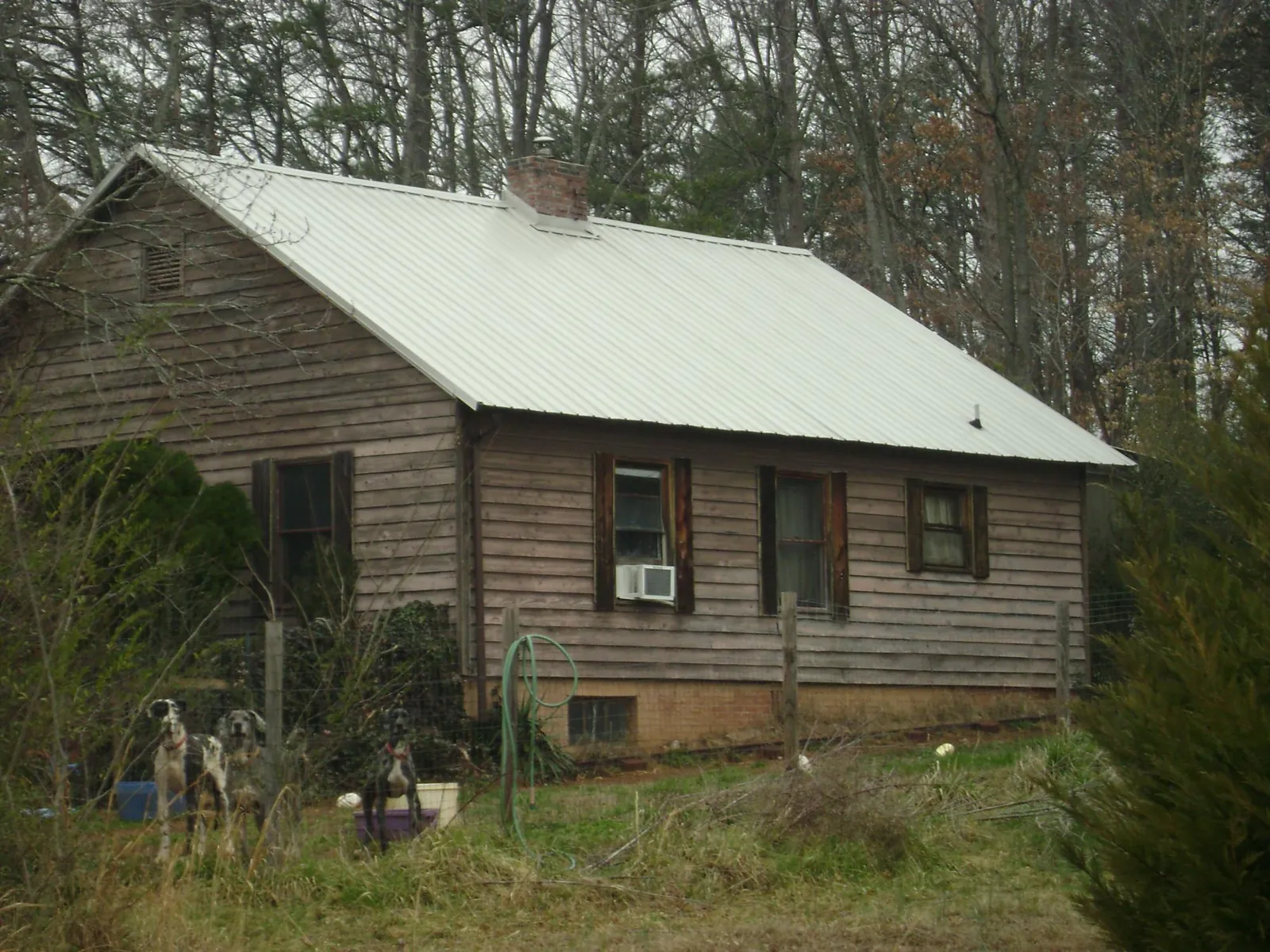 White metal roof on an old wood sided farmhouse, from a Metal Roof Installation job in Pleasant View